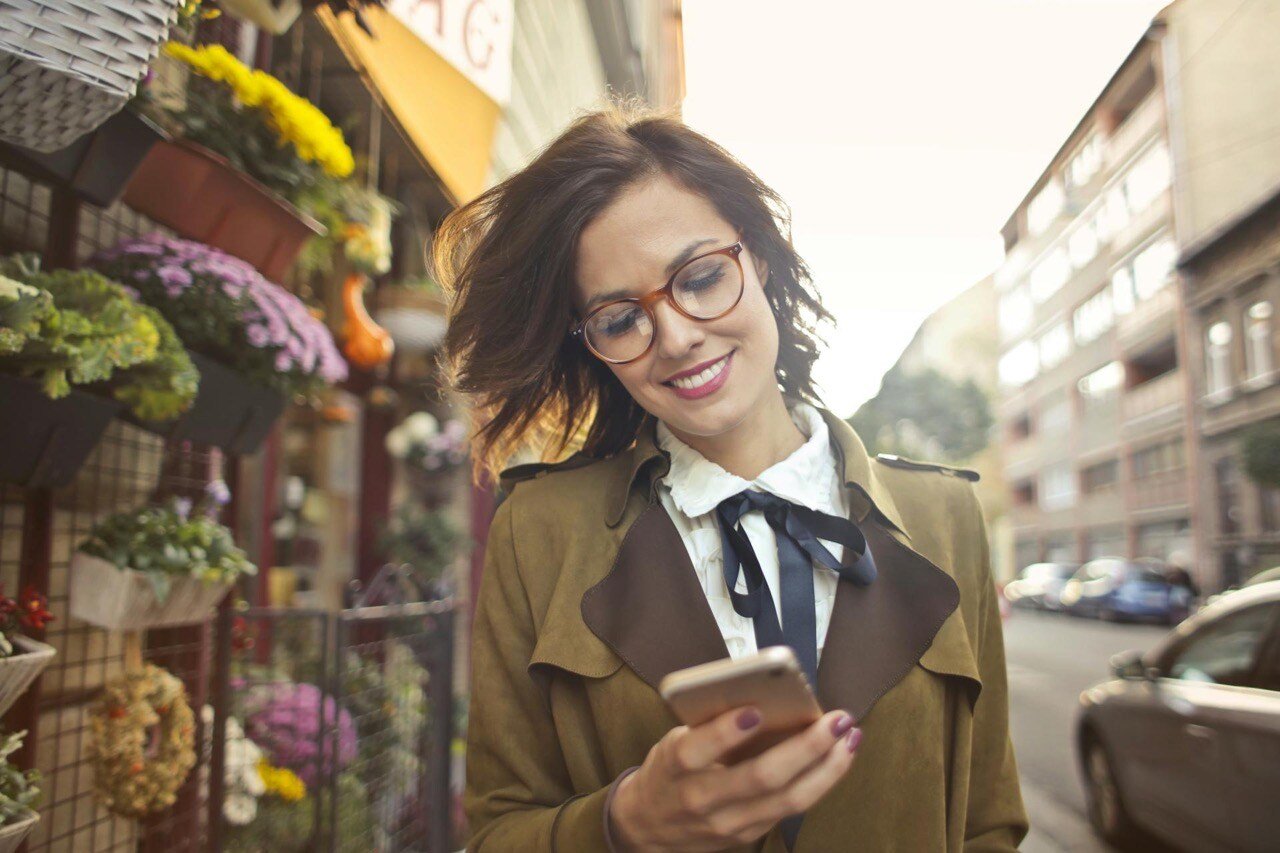 woman customer beside flower shop using smartphone